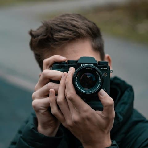 Porträt eines Fotografen mit Kamera in der Hand